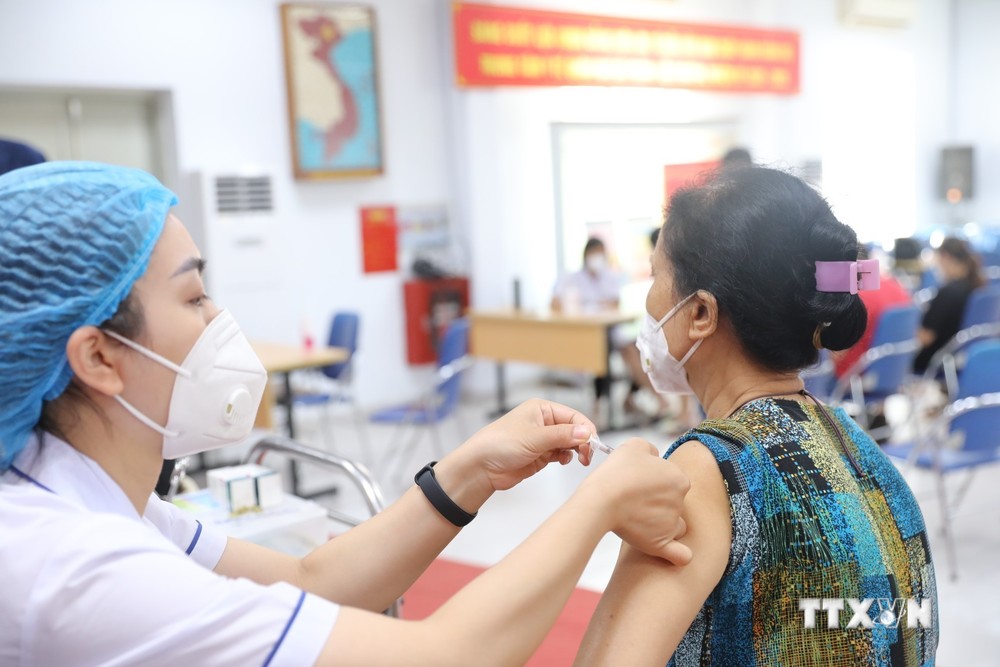 Nhân viên y tế quận Hai Bà Trưng tiêm vaccine phòng COVID-19 mũi 3, mũi 4 cho người dân ngày 5/8/2022. Ảnh: Minh Quyết - TTXVN
