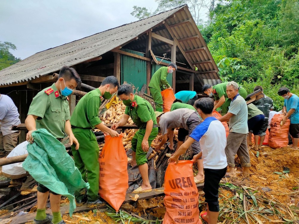 Công an huyện Na Hang (Tuyên Quang) hỗ trợ người dân thôn Khau Phiêng di dời tài sản, hoa màu. Ảnh: Nam Sương - TTXVN