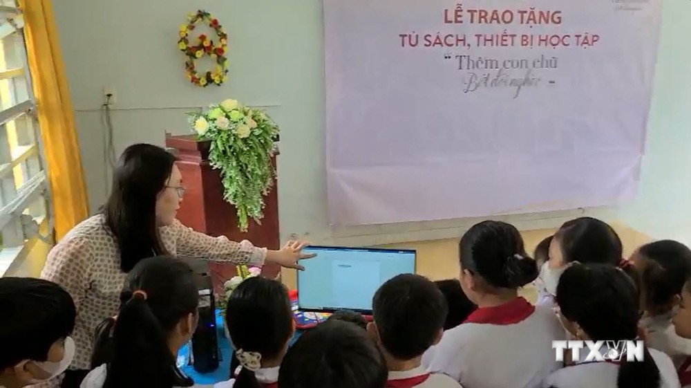 Cô và trò Trường Tiểu học Bình Xuân 1 (thị xã Gò Công) sử dụng máy vi tính vừa được trao tặng từ Chương trình của Agribank Tiền Giang. Ảnh: Hữu Chí – TTXVN

