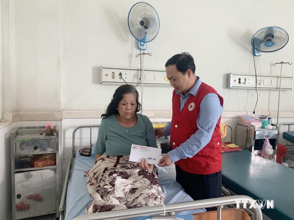 Trao kinh phí của Trung ương Hội Chữ thập đỏ Việt Nam hỗ trợ gia đình có người bị thương trong vụ tai nạn. Ảnh: TTXVN
