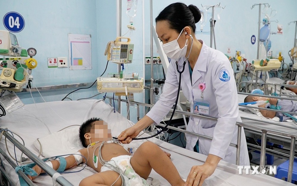 Bác sĩ Bệnh viện Nhi đồng 1 Thành phố Hồ Chí Minh thăm khám cho trẻ mắc bệnh tay chân miệng. Ảnh: TTXVN phát