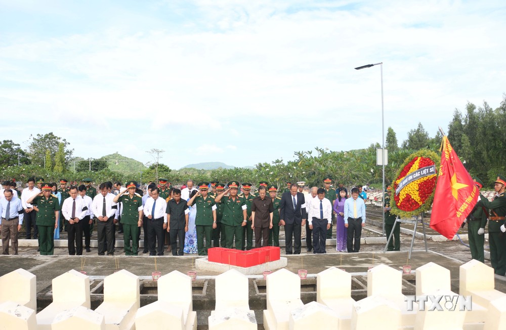Đại biểu thực hiện nghi thức tưởng niệm anh linh các liệt sĩ về an nghỉ tại Nghĩa trang Liệt sĩ Dốc Bà Đắc. Ảnh: Công Mạo-TTXVN