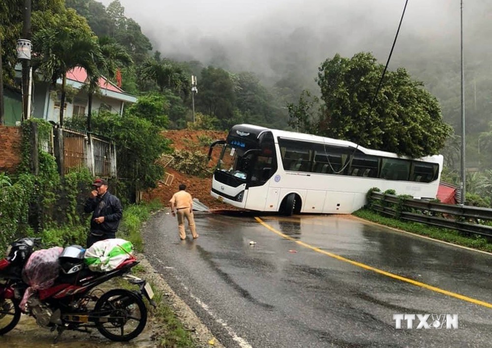 Xe khách lưu thông qua đèo Bảo Lộc bị bùn đất sạt lở suýt rơi xuống vực. Ảnh: TTXVN phát
