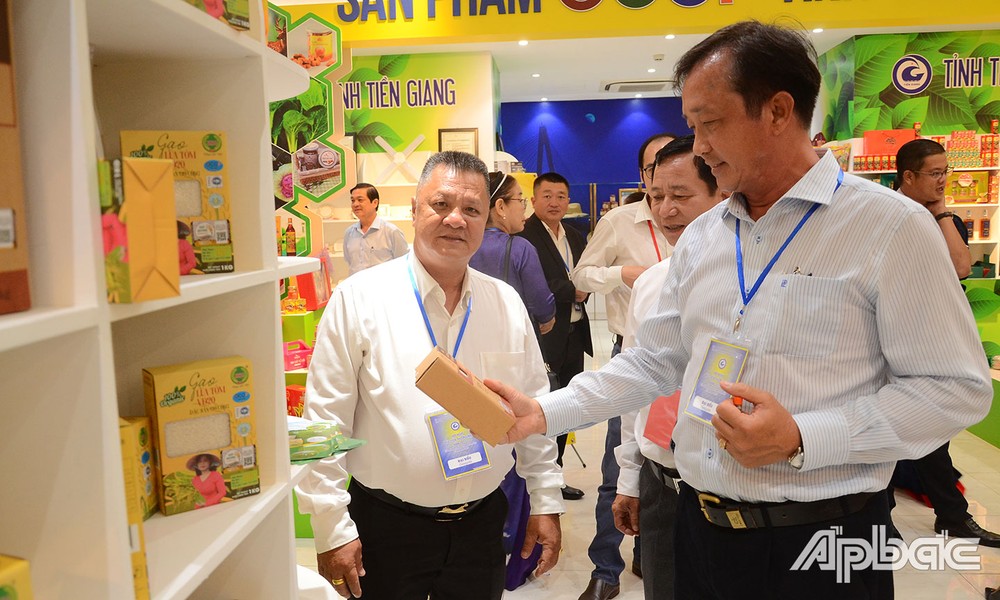 Giám đốc Công ty Trách nhiệm hữu hạn HK Châu Minh Hải (bên trái) giới thiệu sản phẩm gạo với khách tham quan. Ảnh: baoapbac.vn