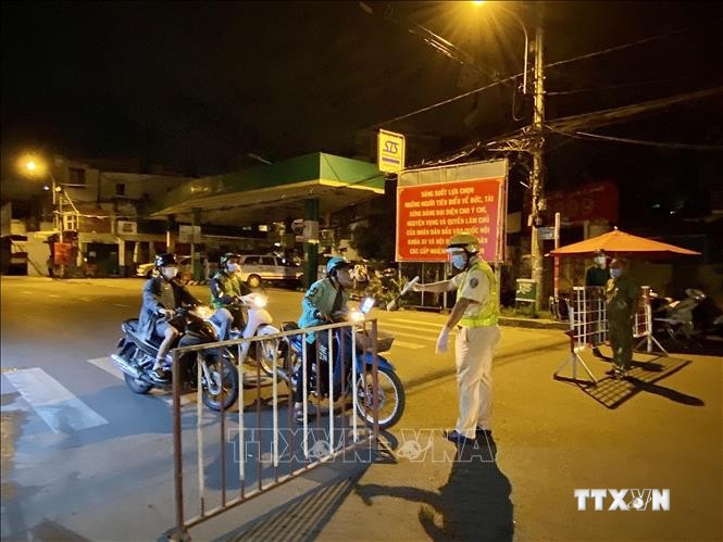 Lực lượng cảnh sát giao thông yêu cầu người dân dừng xe khai báo y tế trên đường Lê Quang Định (phường 1, quận Gò Vấp, Tp. Hồ Chí Minh). Ảnh: Hồng Giang - TTXVN.
