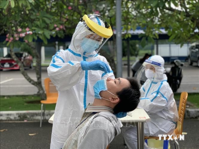 Các y bác sỹ Trung tâm kiểm soát bệnh tật Thành phố Hồ Chí Minh và Quận 7 thực hiện xét nghiệm sàng lọc COVID-19 ngẫu nhiên cho công nhân ở Khu chế xuất Tân Thuận. Ảnh: Thanh Vũ - TTXVN