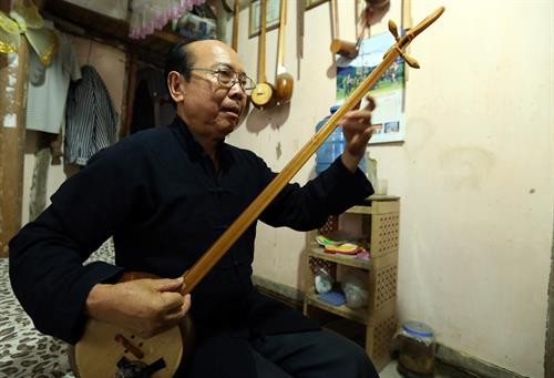 Nghệ nhân Mào Văn Ết - người nặng lòng với cây đàn Tính tẩu. Ảnh: Phan Tuấn Anh - TTXVN